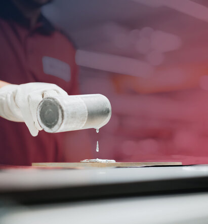 Person gießt flüssiges metallisches Material auf eine Trägerfläche zum Bonden von Targets